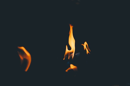 A dramatic dark background with glowing embers and flames, symbolizing spiritual purification.