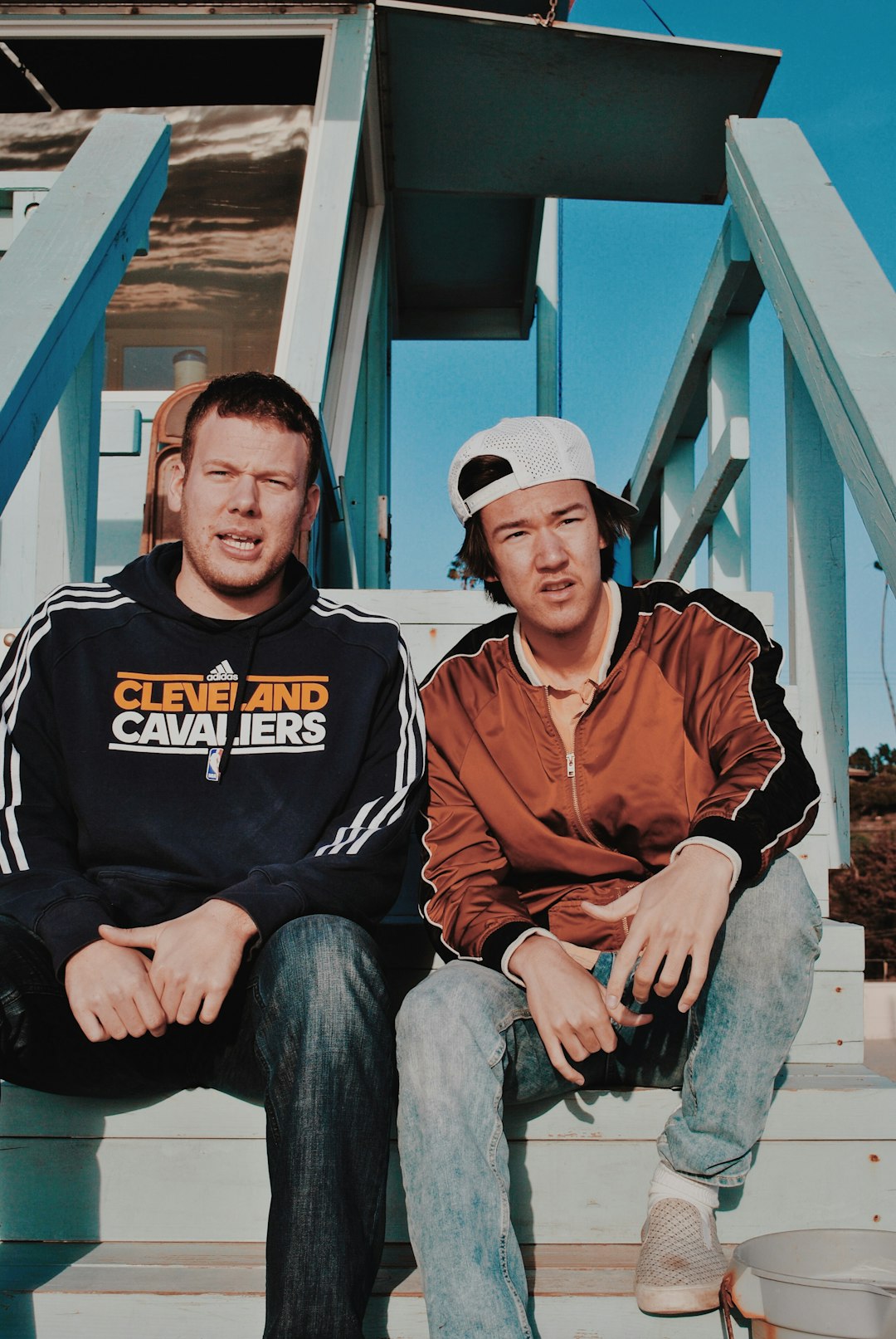 two men sitting on wooden stairs