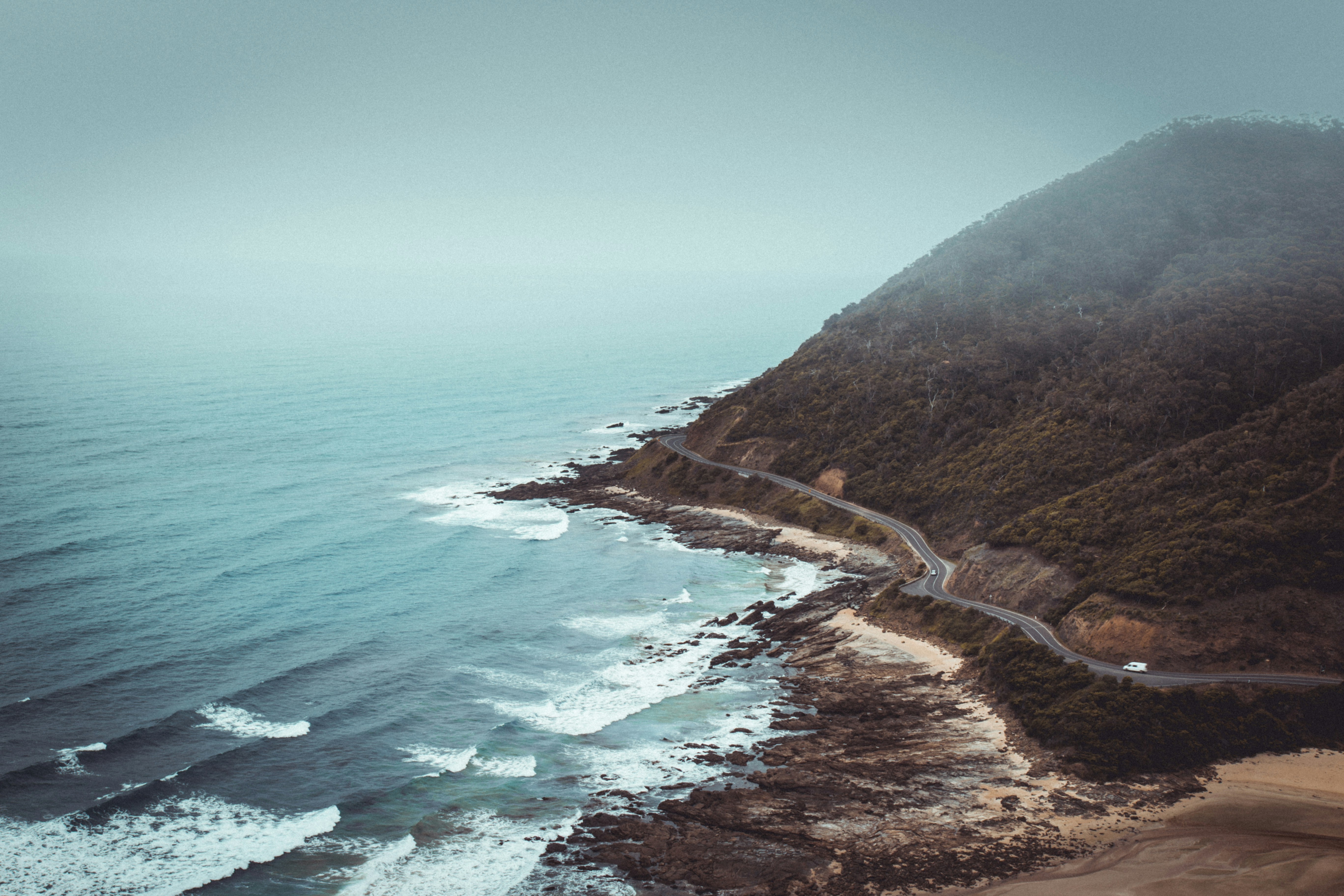 aerial photography of mountains beside road and sea, 