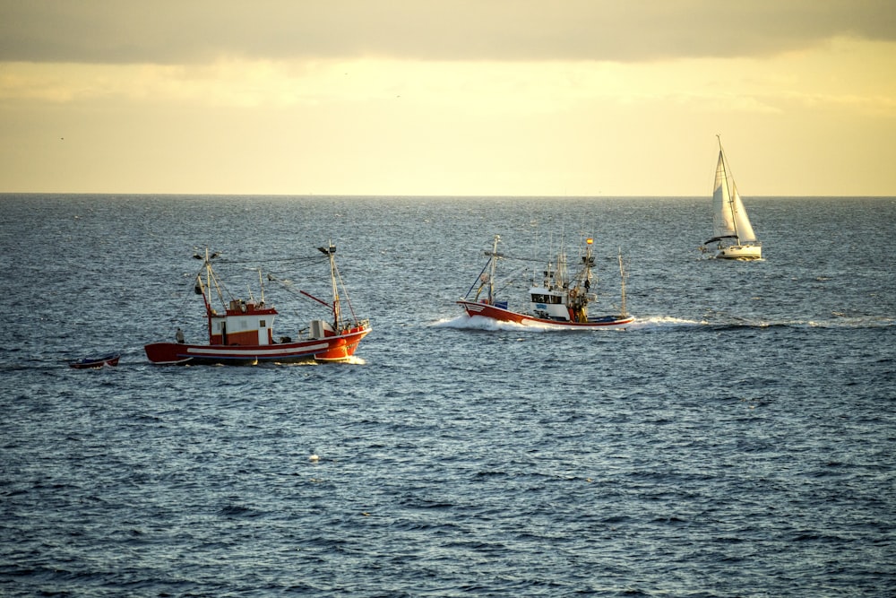 2 trawlers and 1 sailboat out at sea
