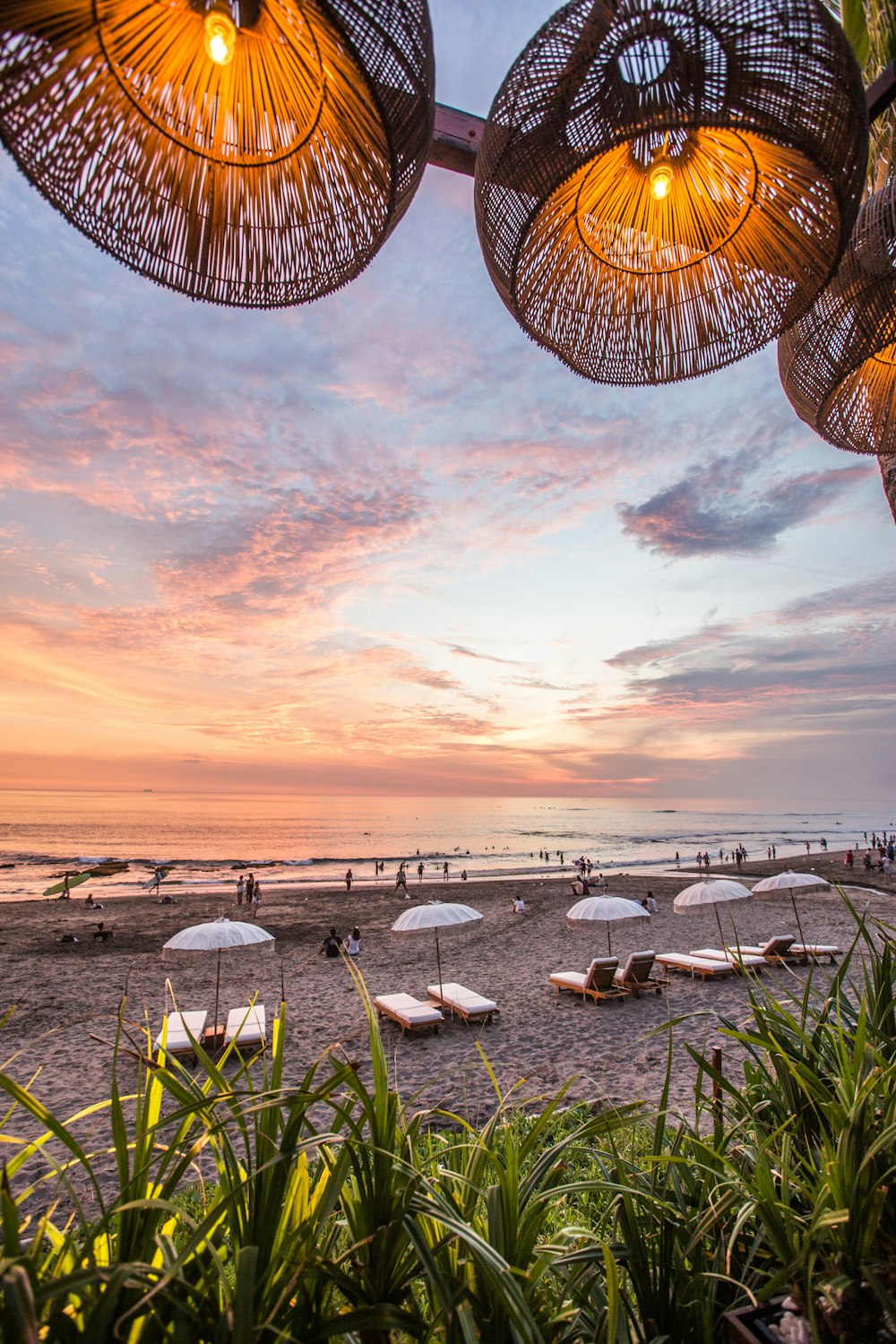 white parasol and lounge near seashores