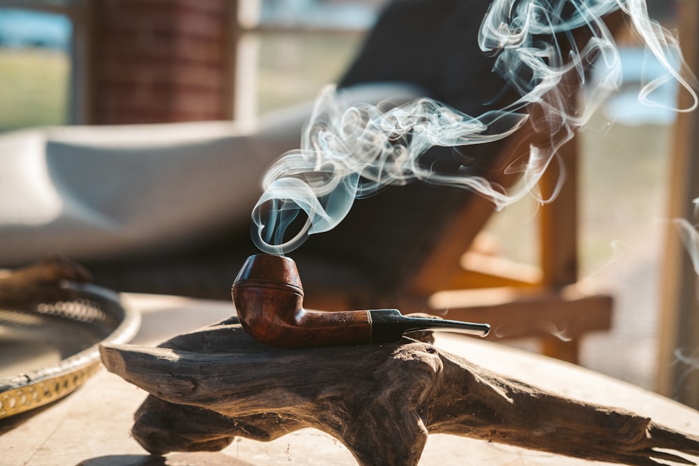 smoke coming from brown smoking pipe