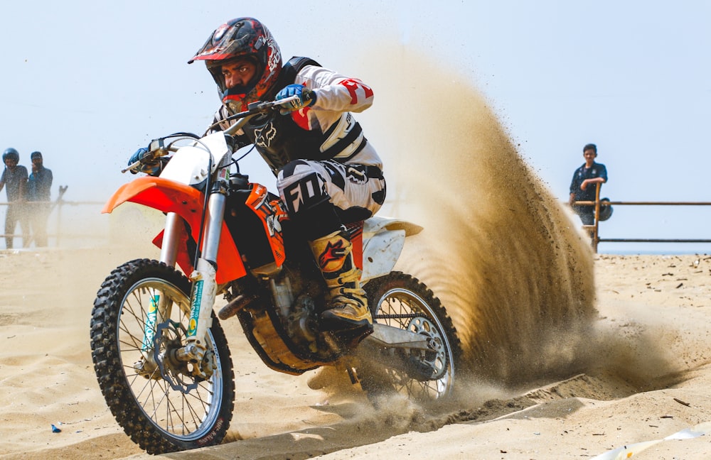 hombre en las dunas de arena montando motocicleta