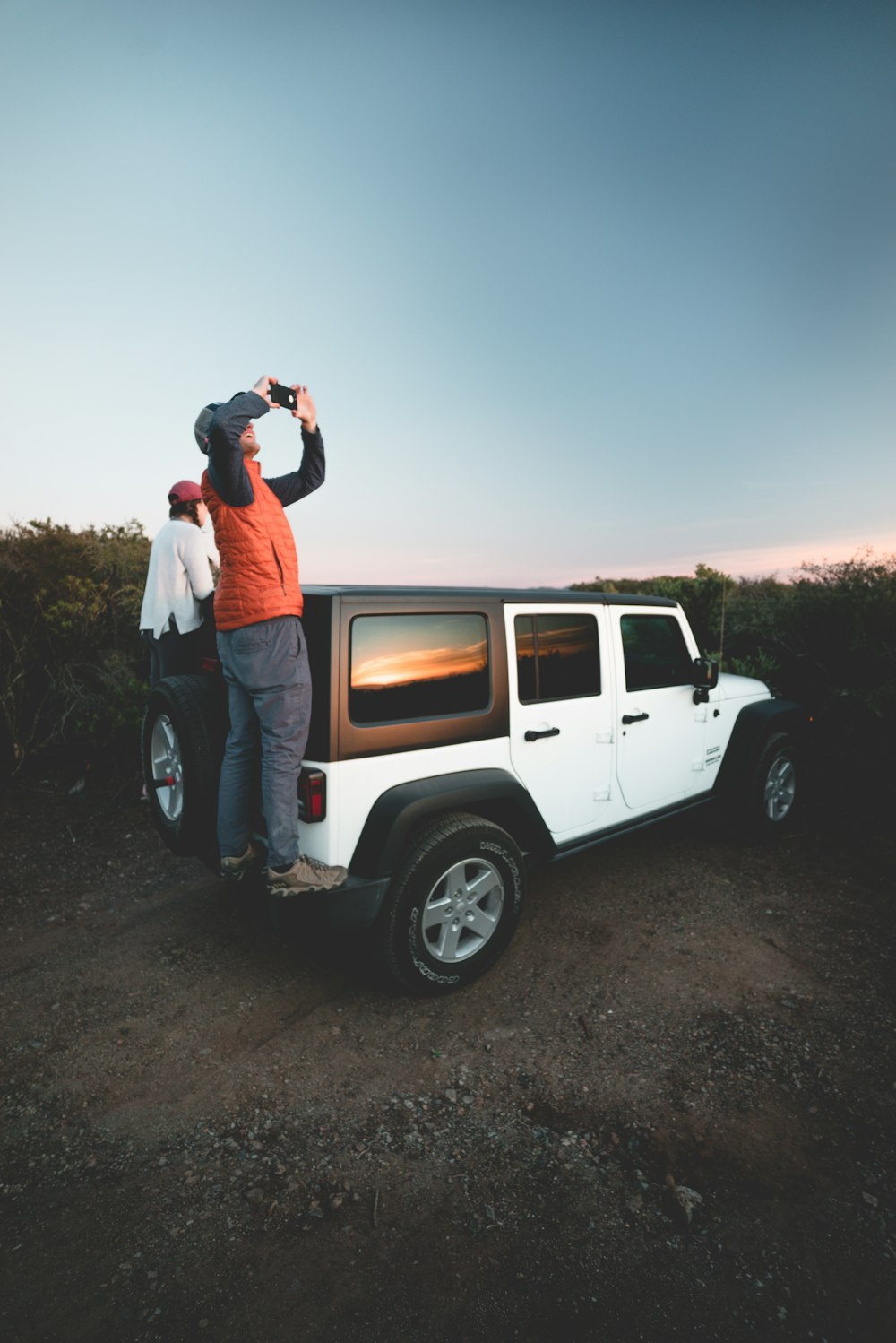 two man standing on vehicle tailgate during daytime