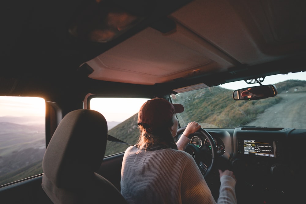 femme conduisant un véhicule sur la route pendant la journée