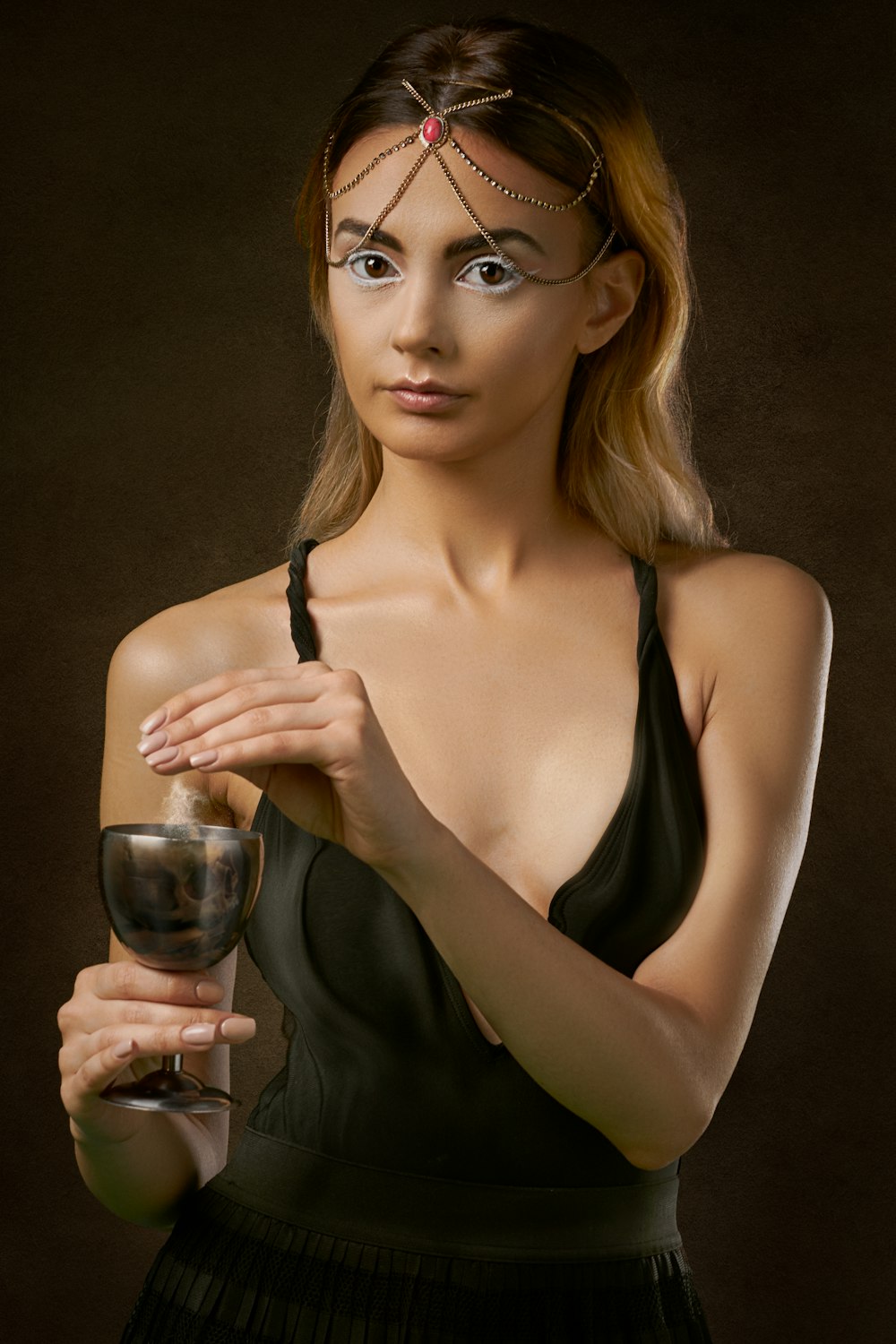 Frau steht und hält ein Glas Wein in der Hand