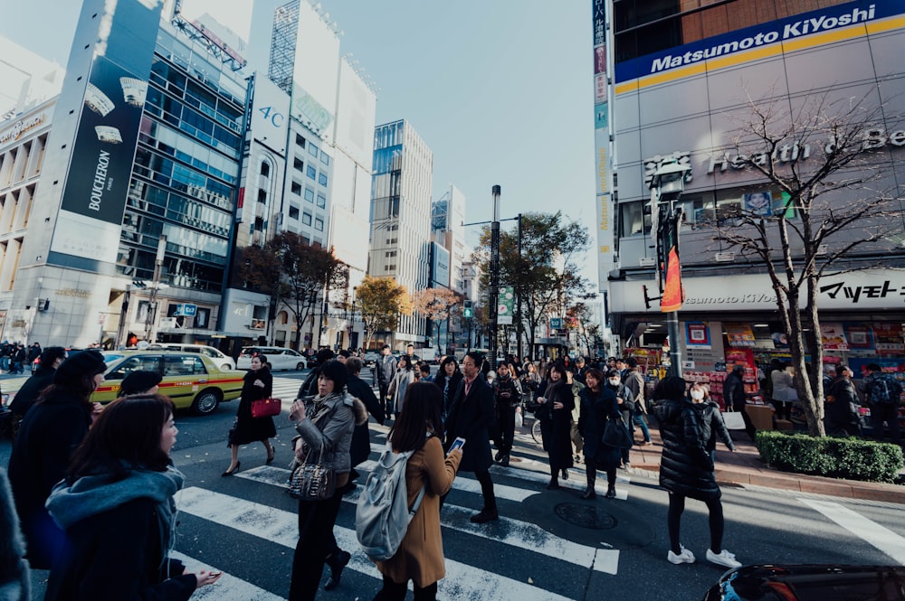 people in black dresses crossing the pedestrian lane