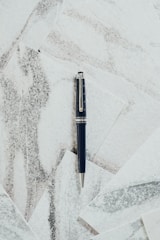 Close-up of a sleek black marble desk with financial charts and a platinum pen.