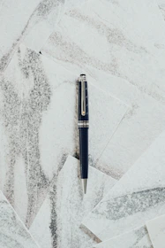 A sleek black and silver pen resting on a clean, modern desk setup.