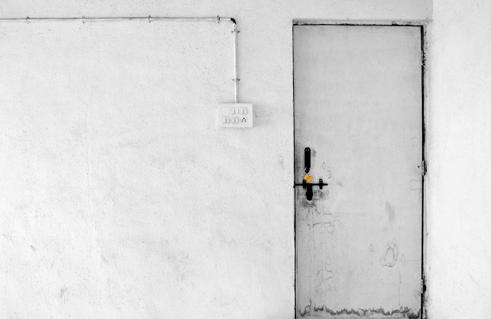 white painted concrete wall with closed door