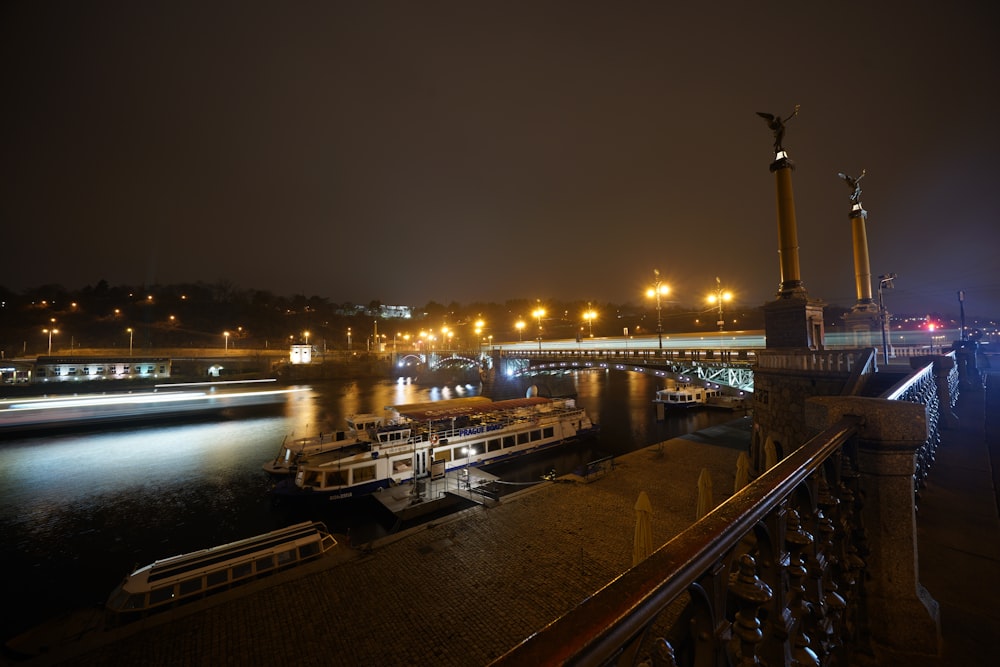 Boote auf ruhiger See in der Nähe von Gebäuden während der Nacht