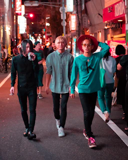 A dynamic shot of friends wearing Neon Rem styles laughing and walking at twilight in the city.