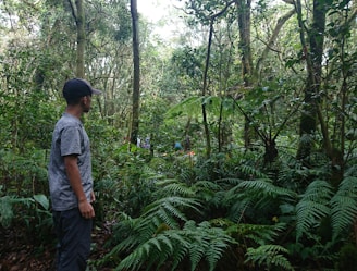 Model wearing eco-friendly clothing standing in a lush green forest