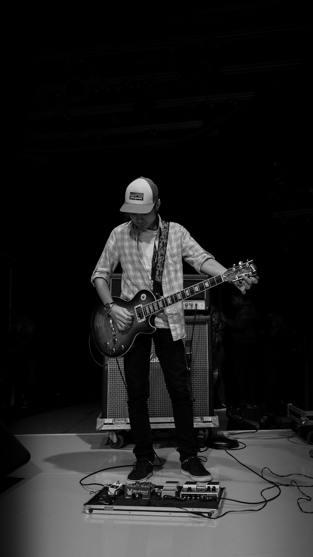 grayscale photography of man playing guitar