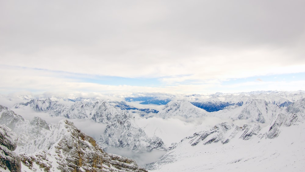 mountain covered by snow under cumulus clouds