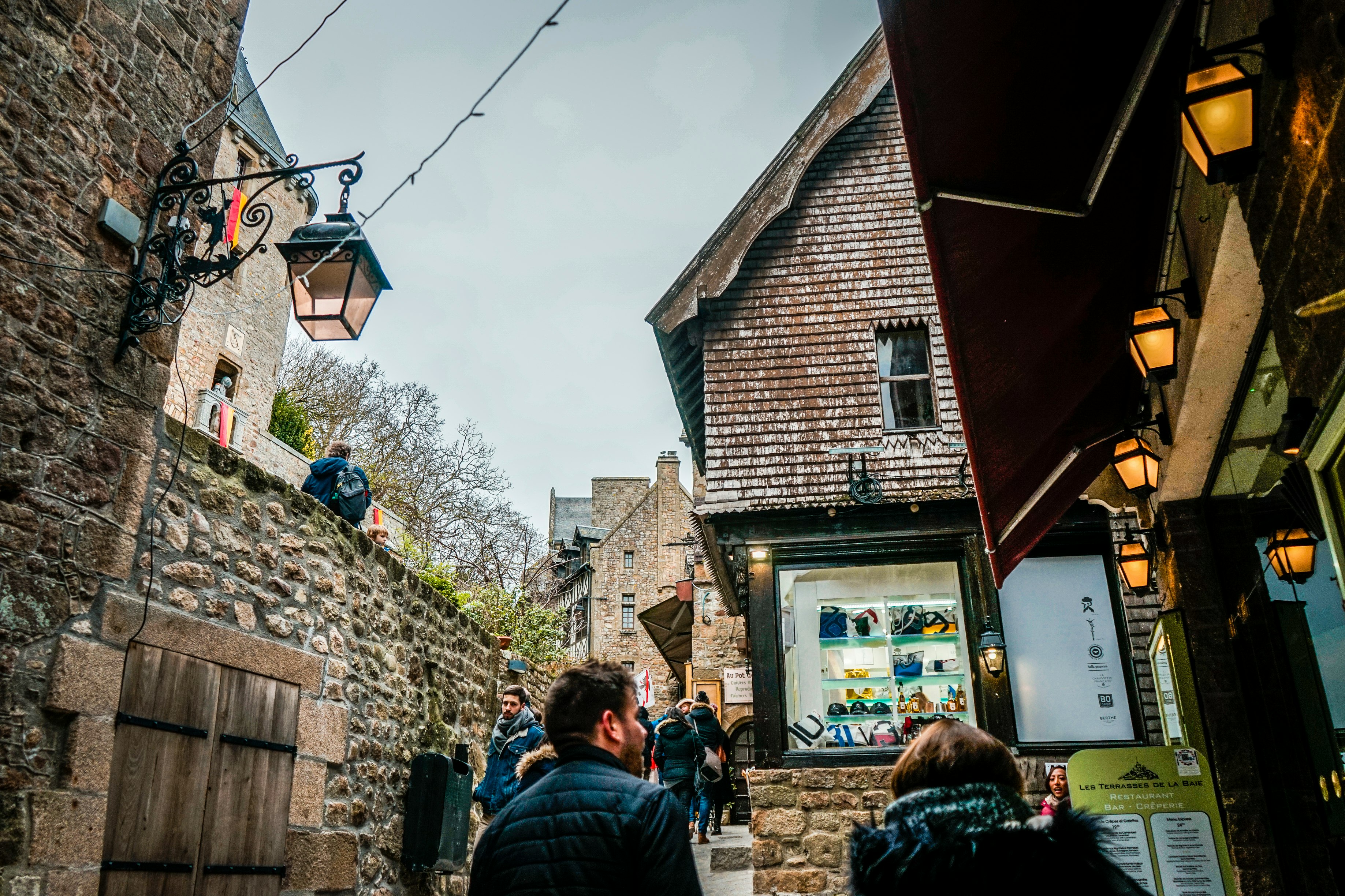 man and woman wearing black bubble jackets standing side by side near buildings