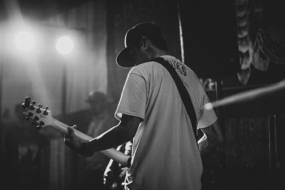 man in T-shirt playing guitar