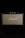 A vintage-style speaker with the brand name prominently displayed in white script against a woven fabric grille. The speaker casing has a textured black finish and gold control knobs on top, set against a black background.