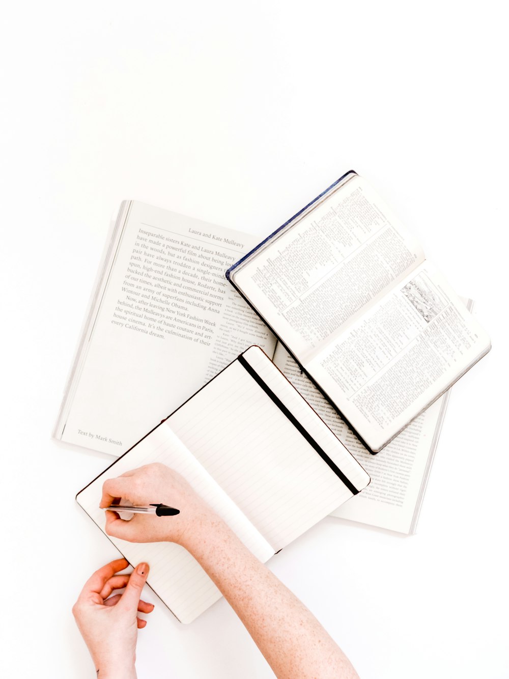 person about to write on planner near open bible