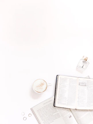 A lively flat lay of sexbooks, a cup of tea, and colorful bookmarks scattered on a bright surface.
