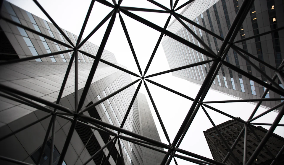Steel beams and columns form intricate lattice pattern on modern skyscraper's exterior facade