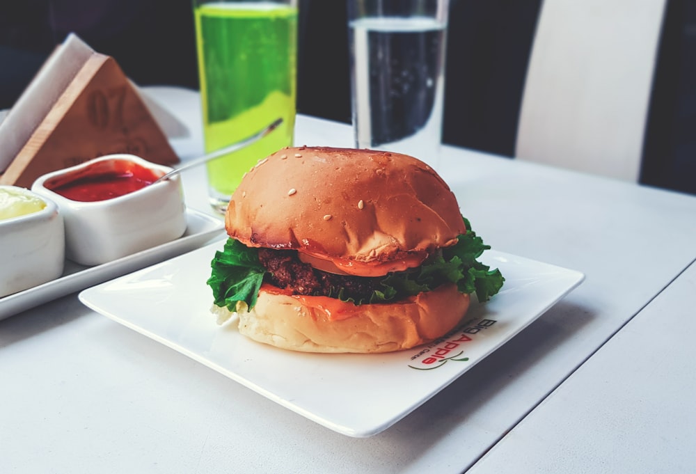 burger with green lettuce on white ceramic plate