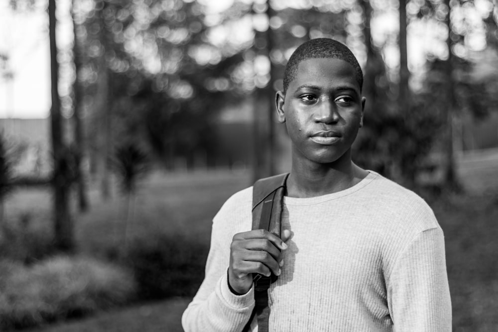 grayscale photography of man holding backpack