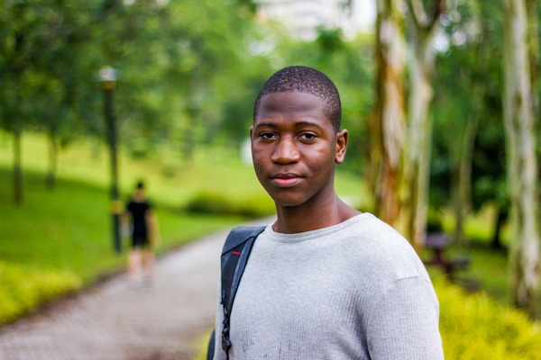 Young man in a gray crew-neck shirt outdoors
