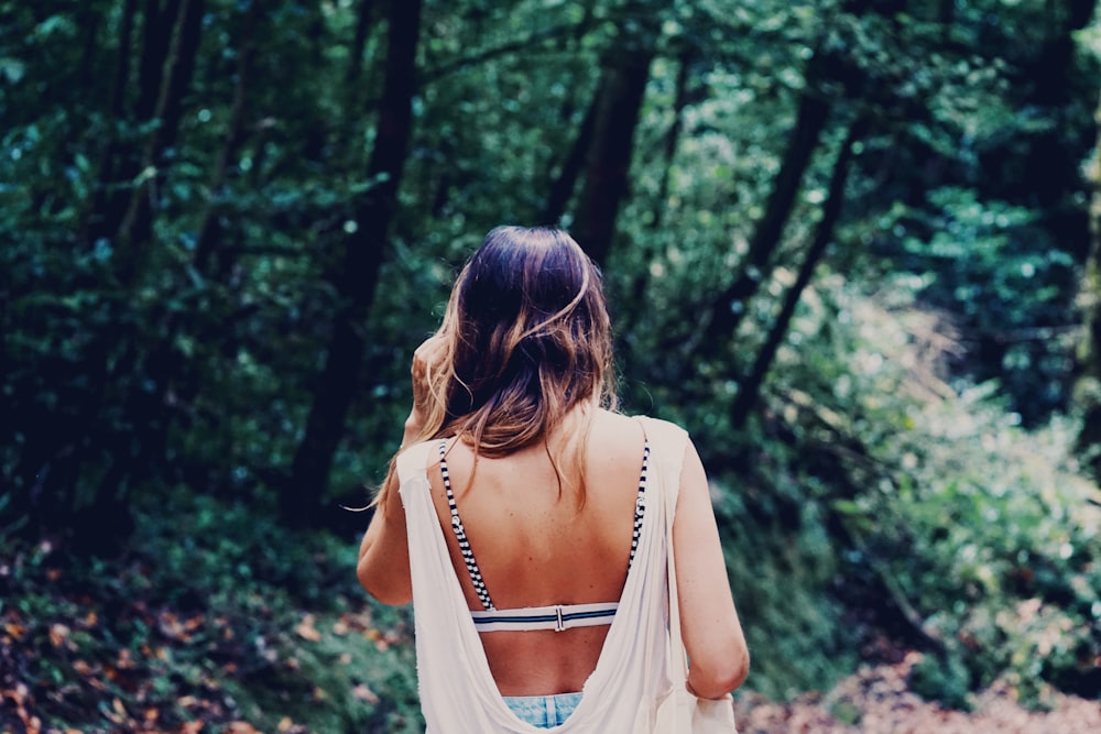 woman standing near green-leafed trees during daytime