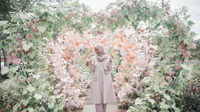 woman standing between heart framed flower garden \