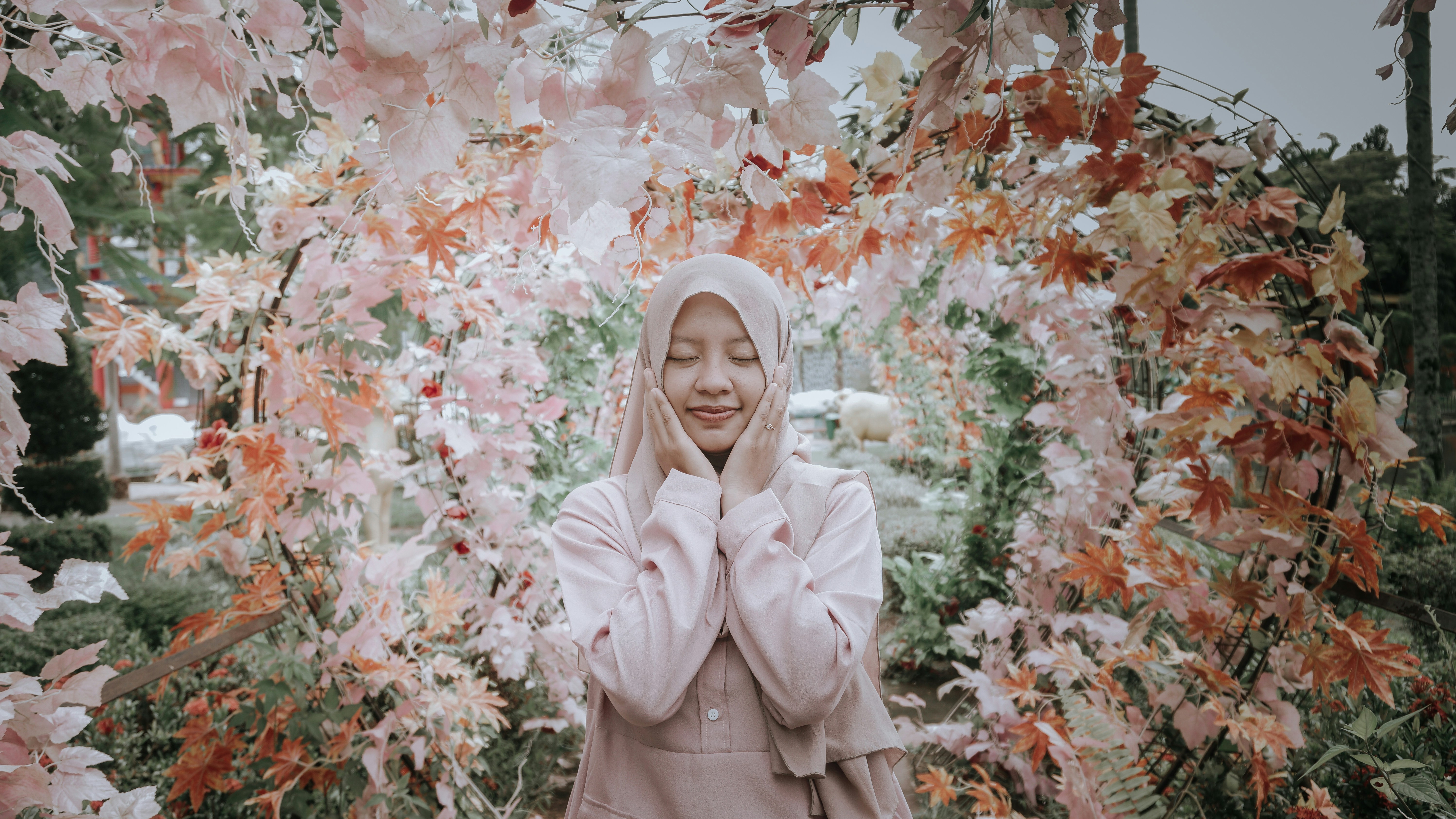 wanita berhijab merah muda