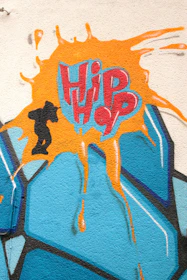 A close-up of hands painting graffiti art that tells a story of hip-hop’s roots and evolution.