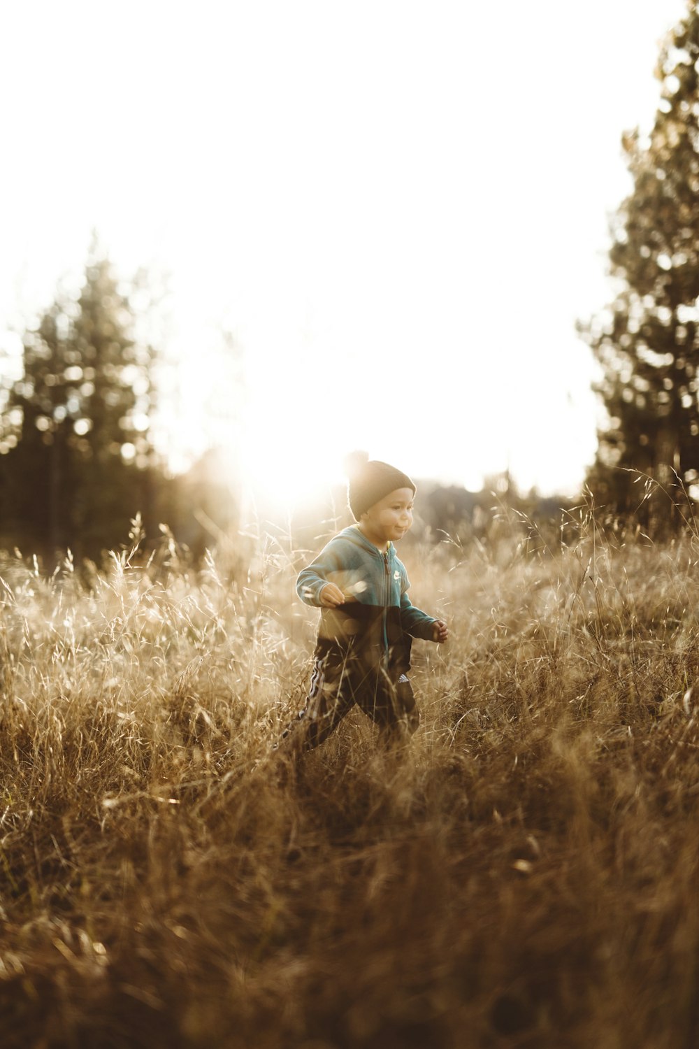 boy standing on brown grasses