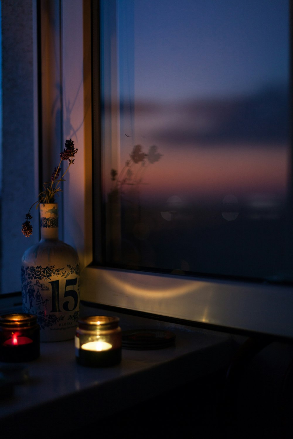 two lighted tealights near closed window