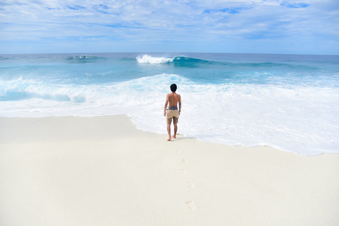 man in beige shorts near seashore