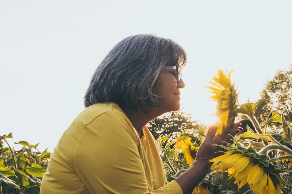 woman smelling sunflower