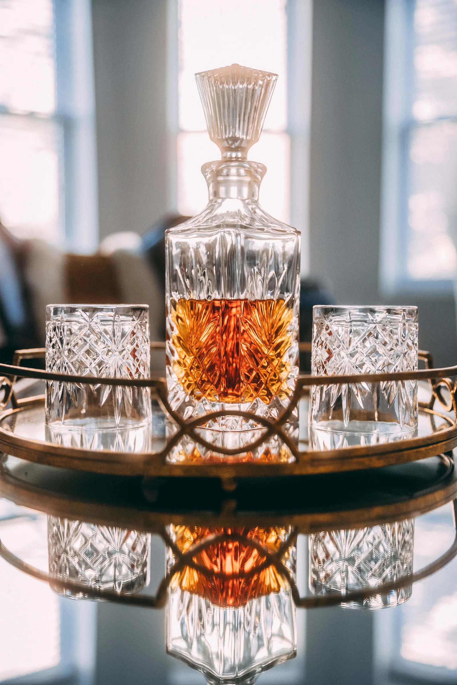 A cut glass decanter of whisky standing in low light.