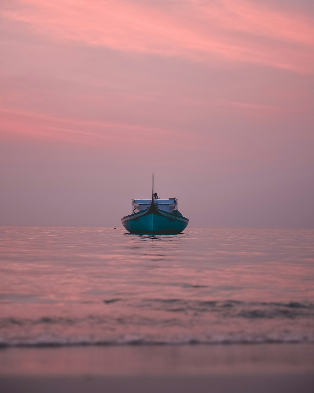 blue boat in middle of body of water during daytime