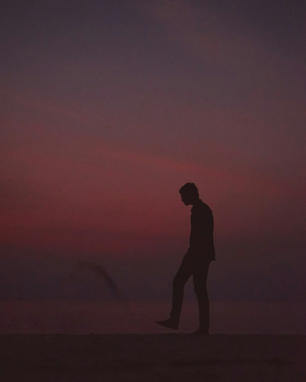 man silhouette playing with sand