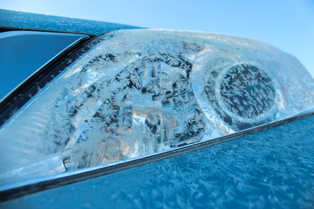 Frosty car headlight covered in ice crystals during extreme polar vortex conditions