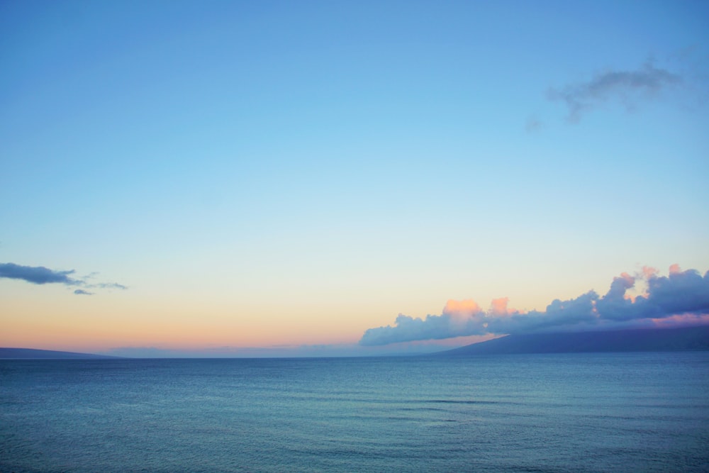 body of water under cloudy sky