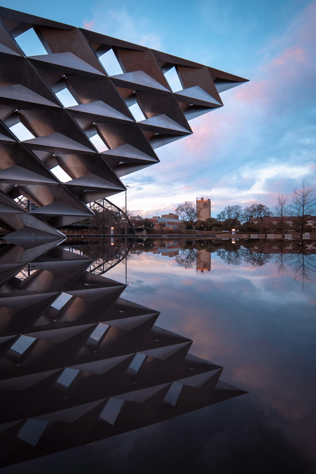 gray building reflecting on body of water