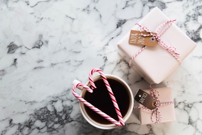 white ceramic mug beside gift boxes candy cane zoom background