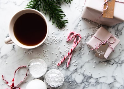 white ceramic teacup candy cane teams background