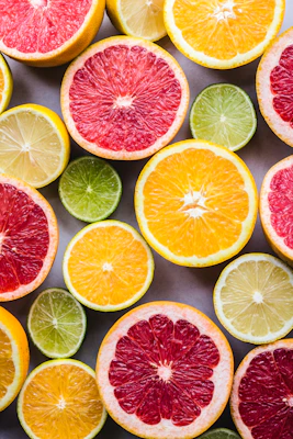 flat lay photography of sliced pomegranate, lime, and lemon