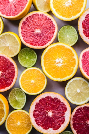 flat lay photography of sliced pomegranate, lime, and lemon