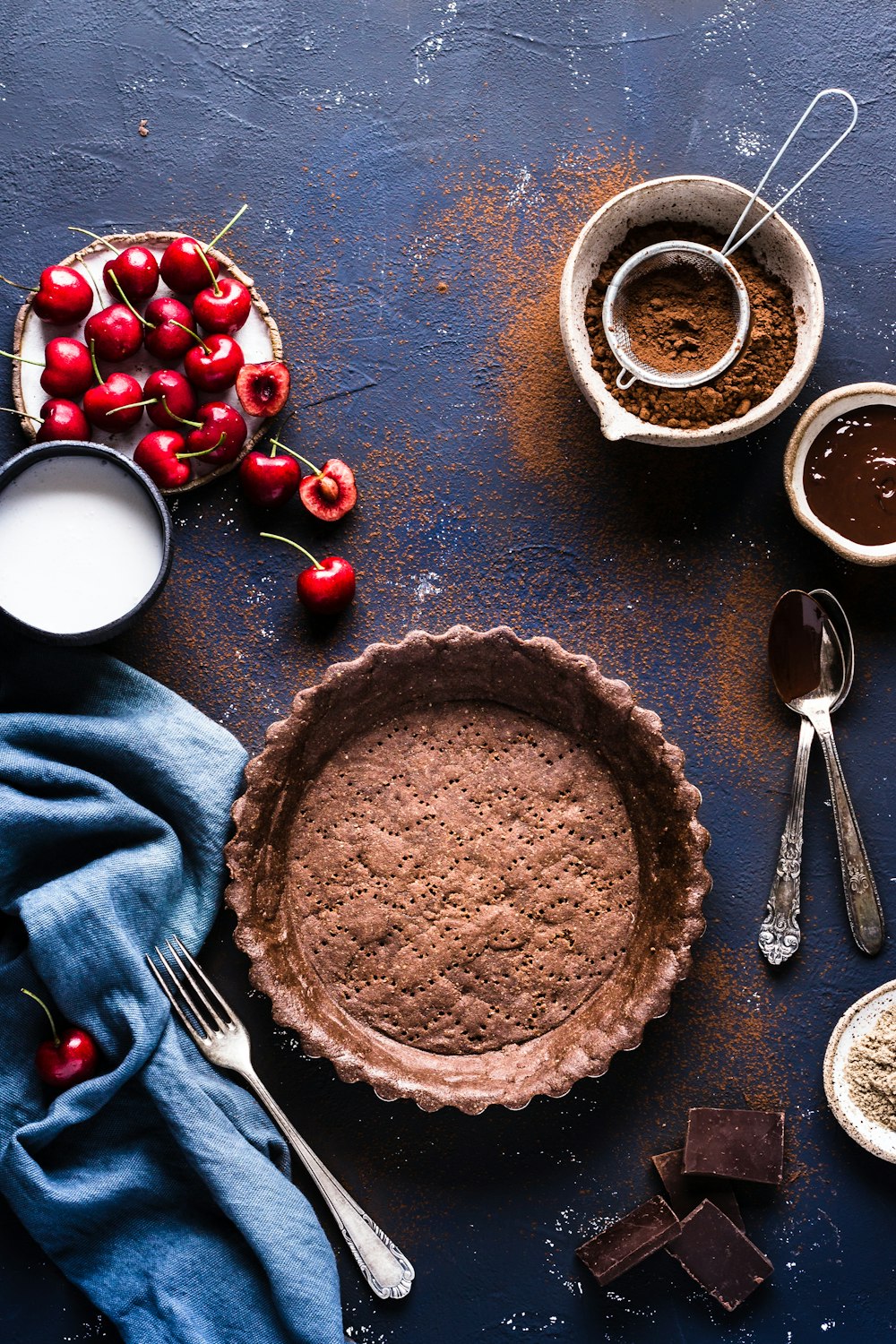 flat lay photograph of pie tray, cherries, and powder