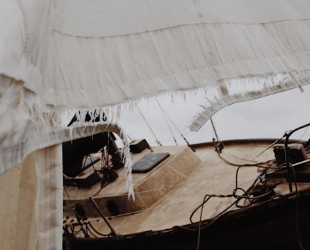 Canvas boat cover with custom stitching and repaired sections outdoors