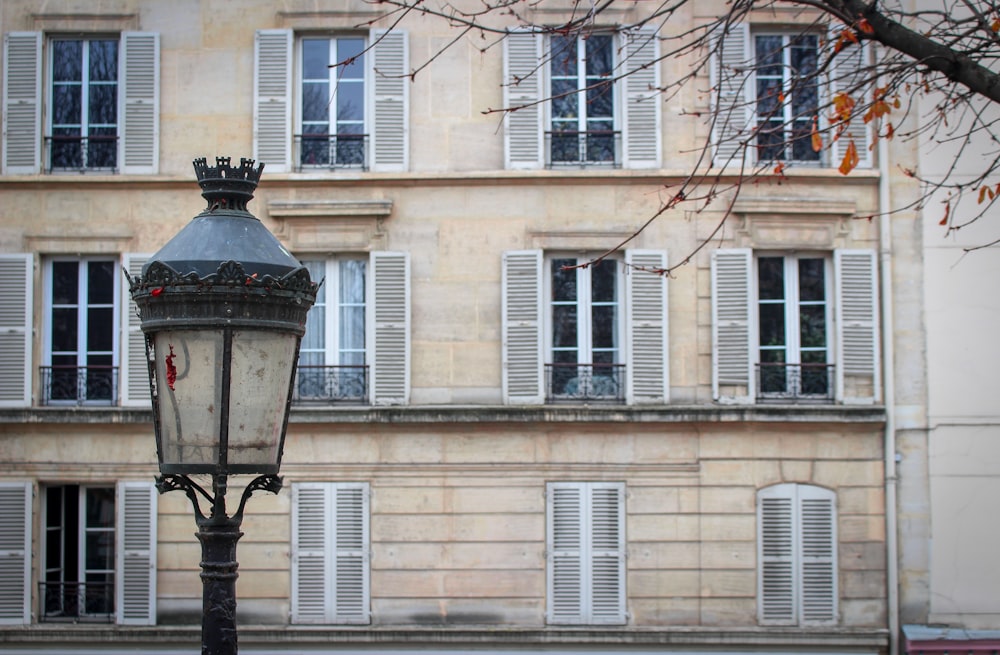 Lampadaire noir près d’un bâtiment en béton beige