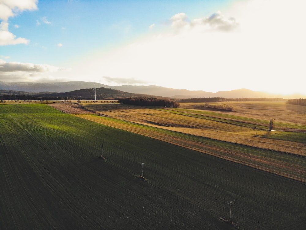 landscape photo of grass field under cloudy sky